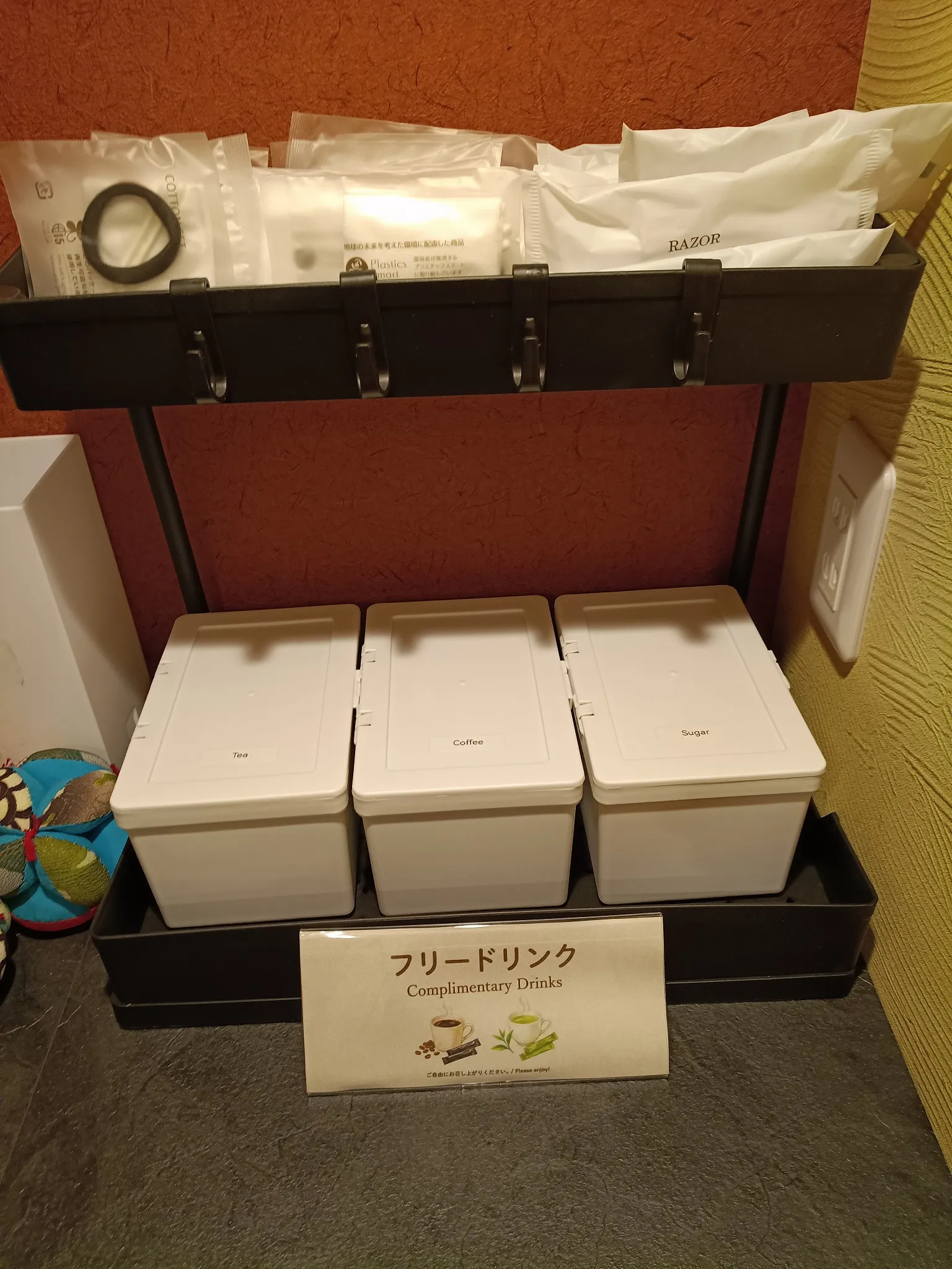 A shelf with tea, coffee and sugar canisters, toothbrush sets and razors