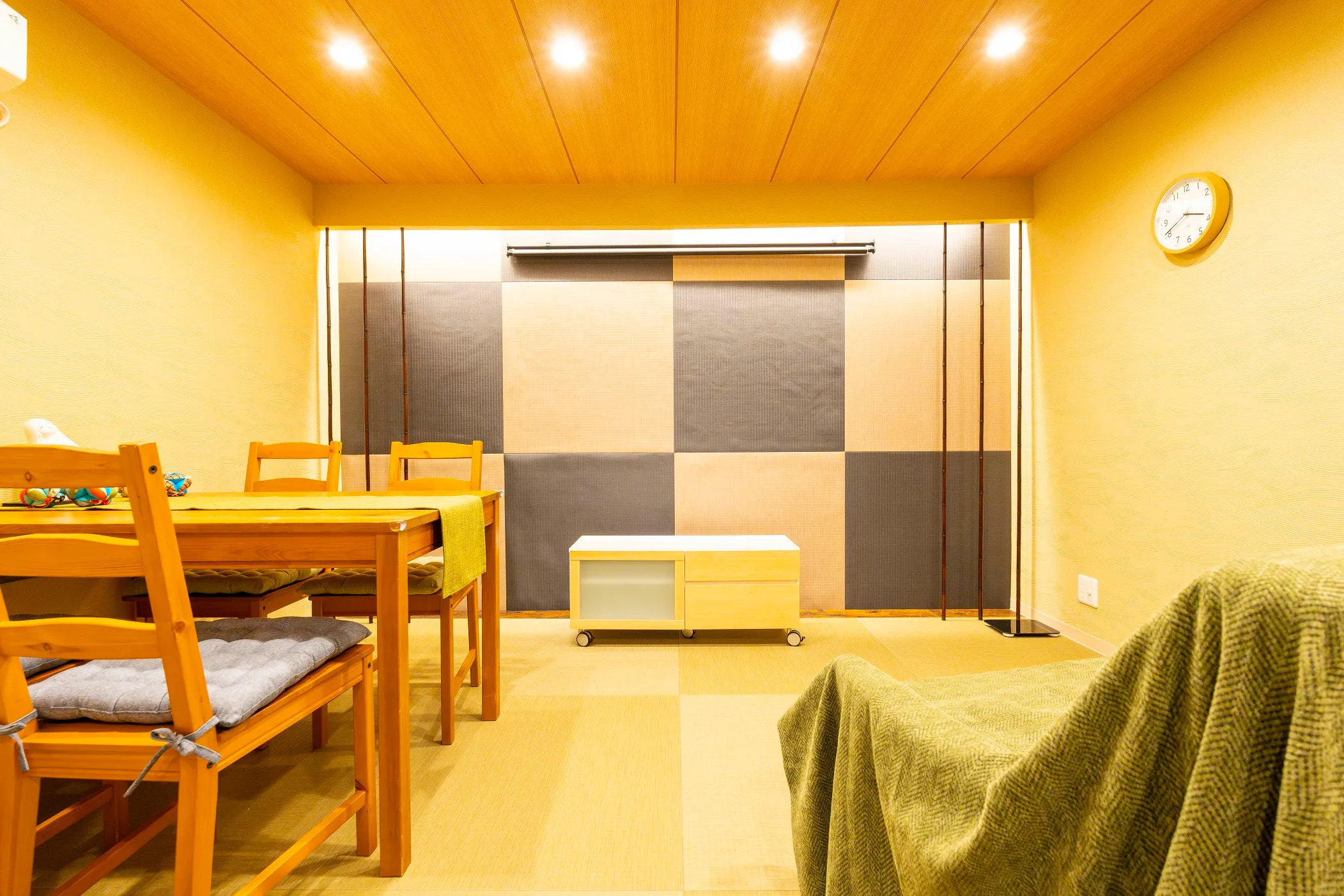 The living room, with Ryukyu tatami laid in a checkerboard and an ichimatsu panel along the wall